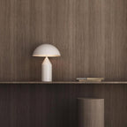 White table lamp on a wooden shelf against a wooden wall