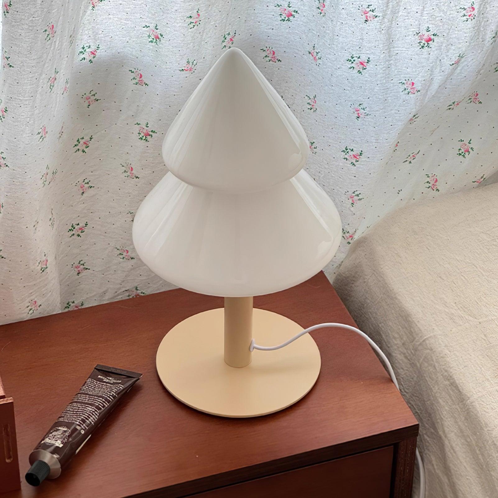 White table lamp on a wooden surface with floral wallpaper in the background