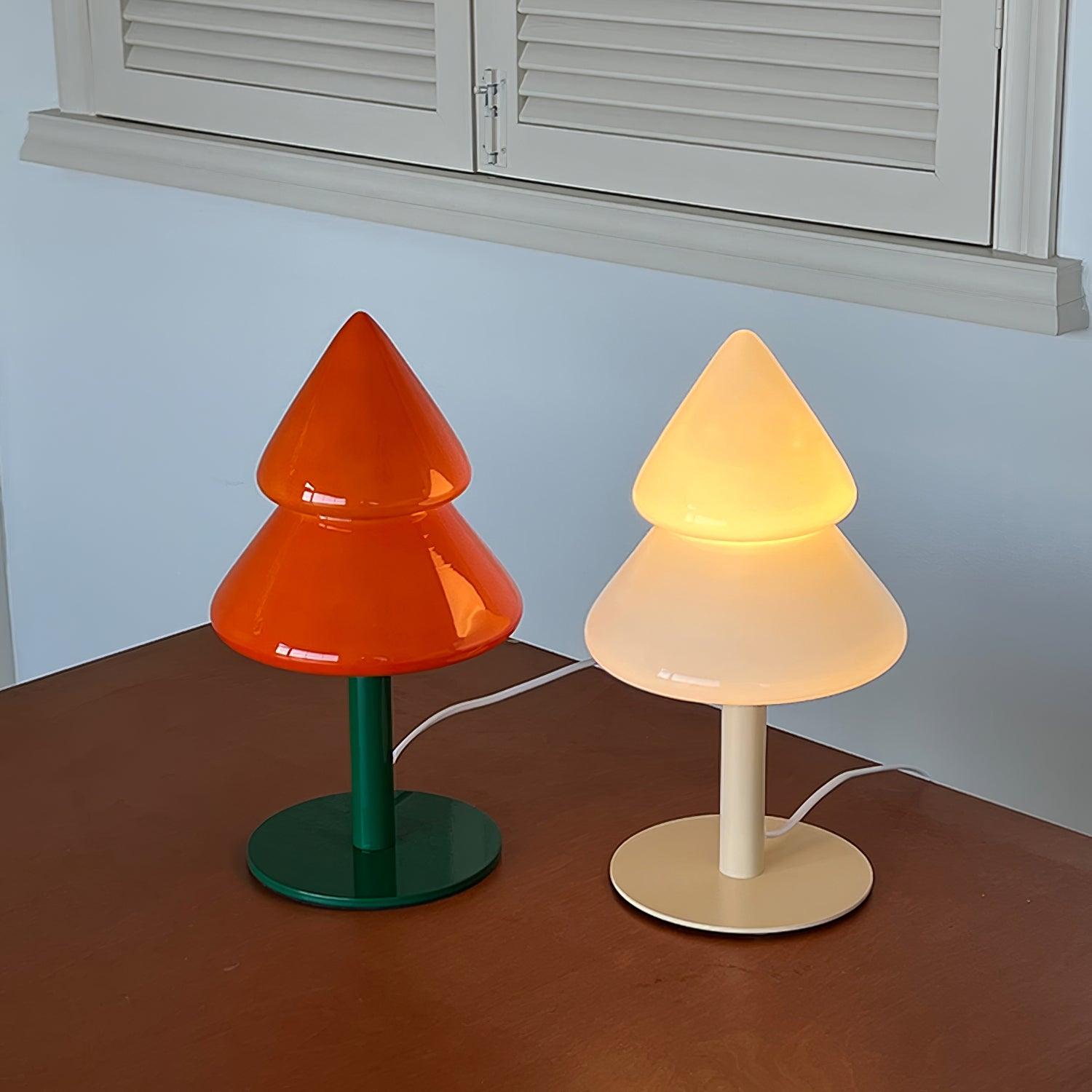 Two unique table lamps on a wooden surface with a light blue wall and window frame in the background.