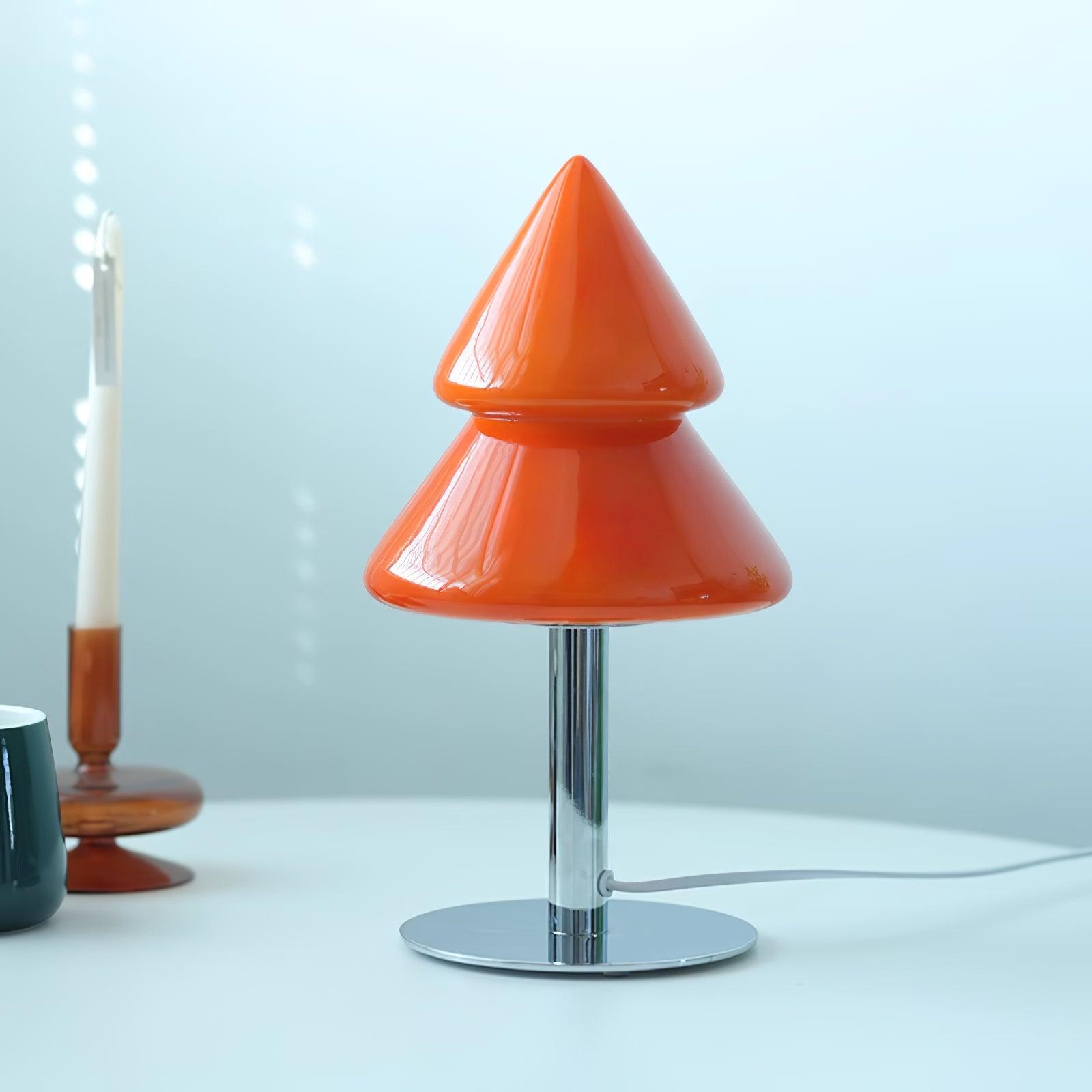 Orange cone-shaped table lamp on a white surface with a light blue background