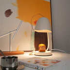 Table lamp on a desk with a candle and books, warm lighting