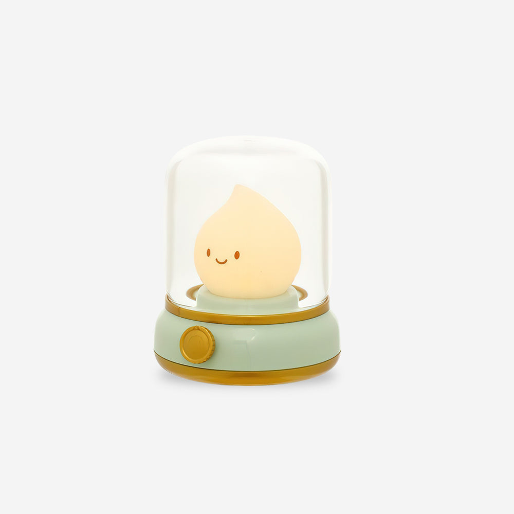 Small lamp with a smiling face inside a glass dome on a white background