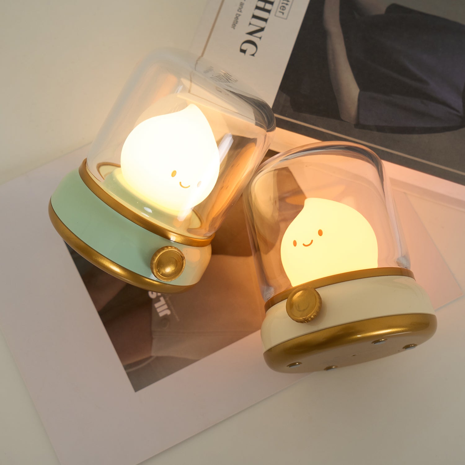 Two cute night lights with smiling faces on a white surface.