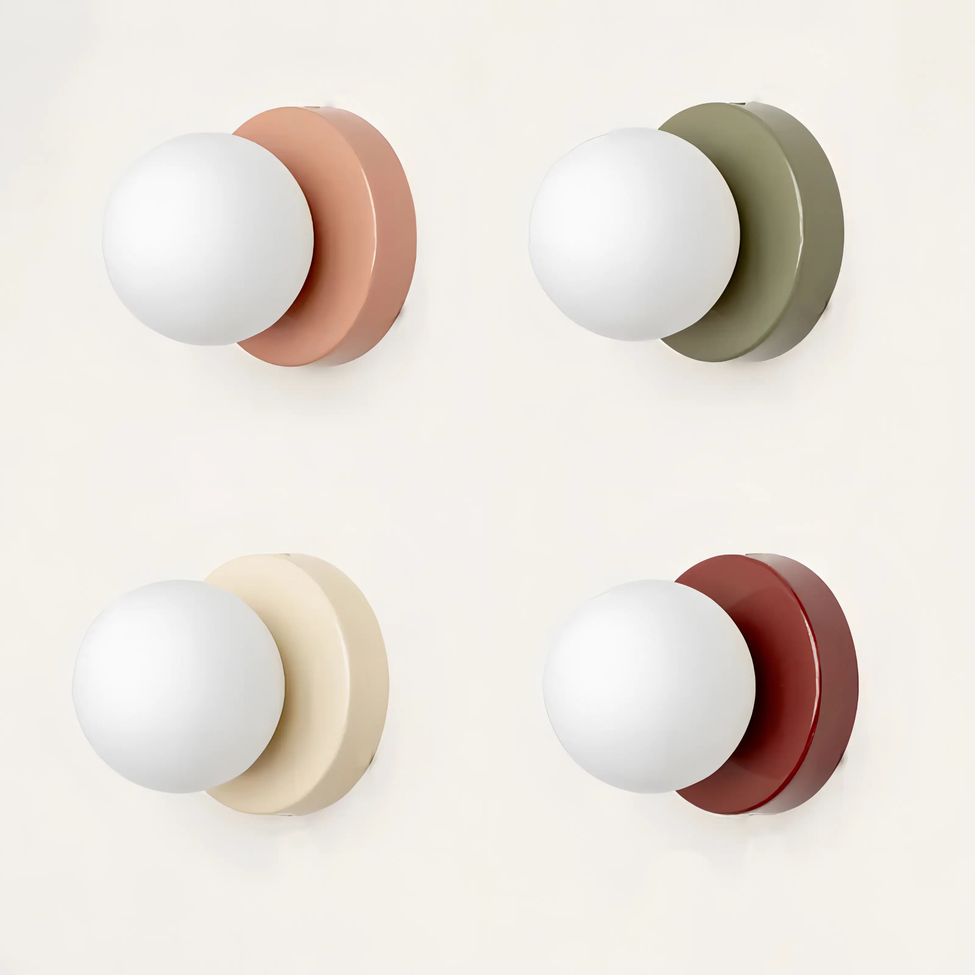 Four wall sconces with different colored bases on a white background