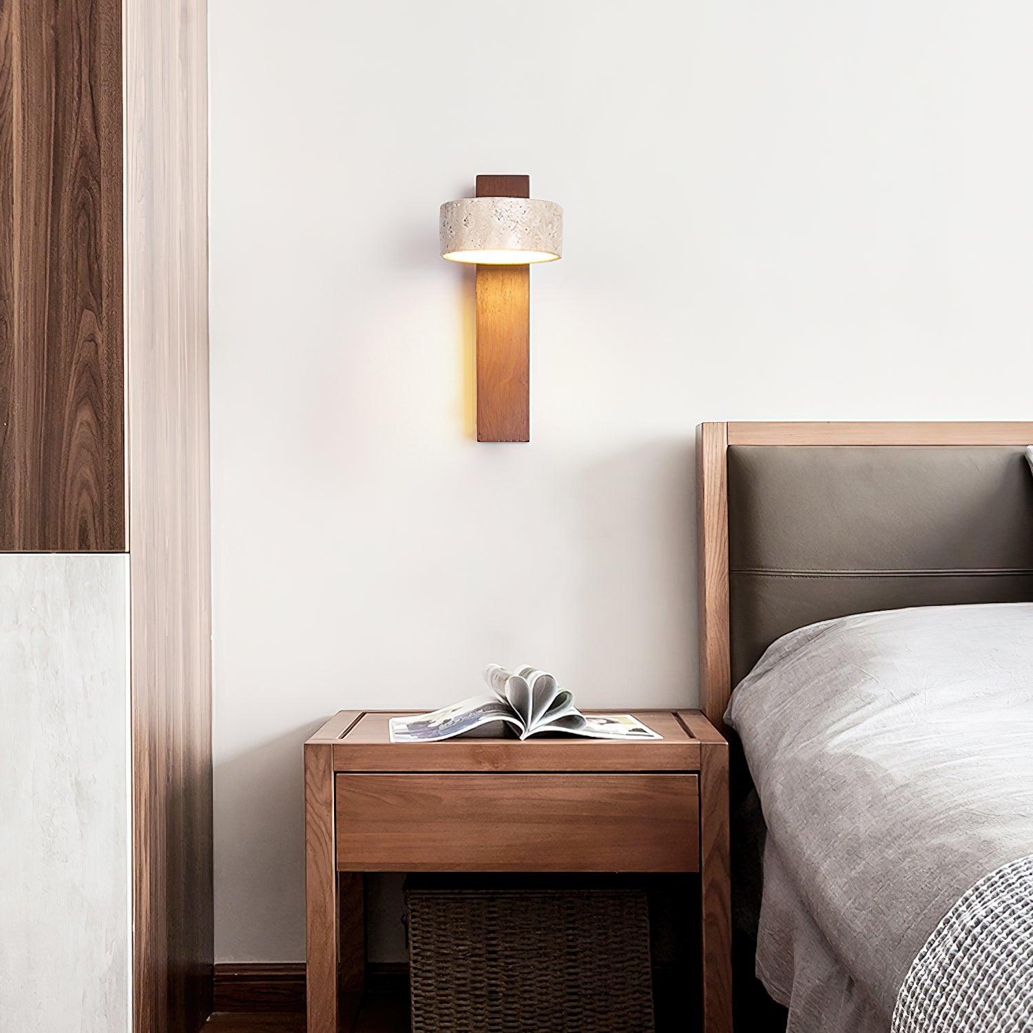 Wooden nightstand with open book next to a bed in a bedroom setting