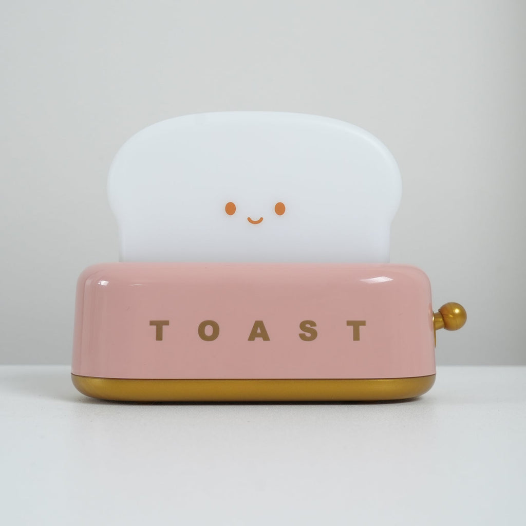 Pink toaster with a smiling face on a white background