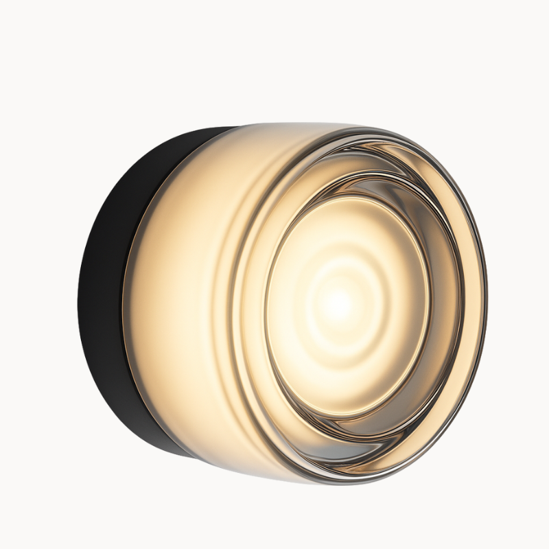 Modern wall light fixture with gold and black design on a beige background