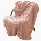 Pink textured blanket draped over a chair in a beige background