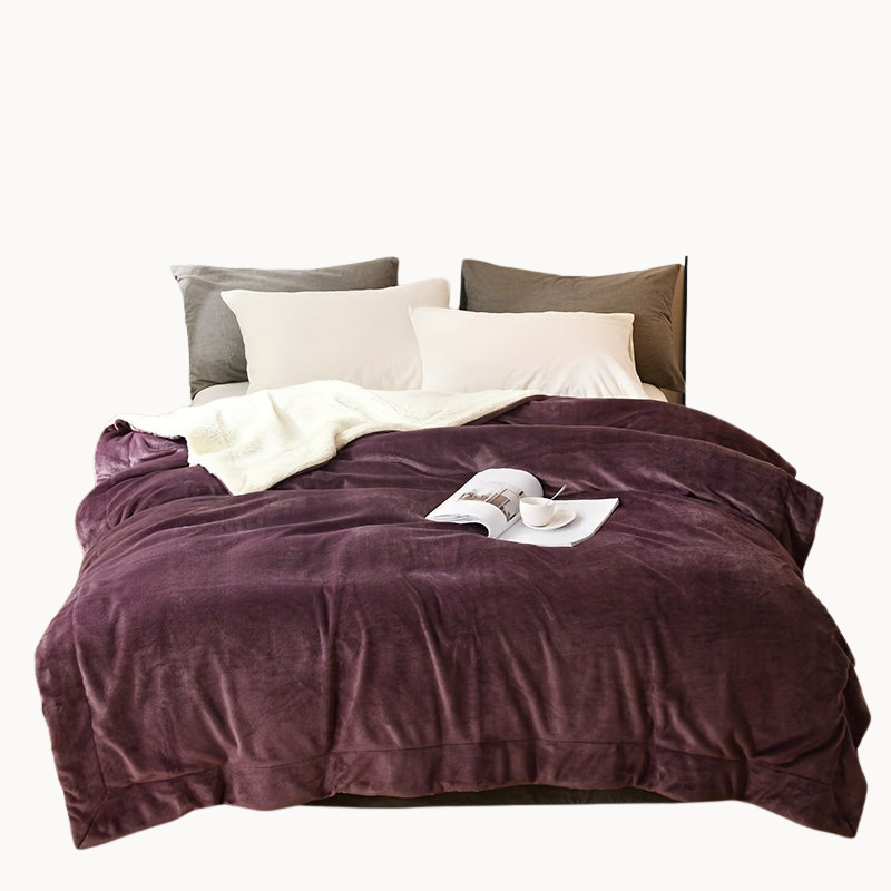 Bed with purple comforter and white pillows in a beige background