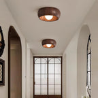 Two wooden ceiling lights in a room with a decorative door and window.