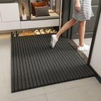 Person stepping onto a textured black mat with shoes displayed in the background.