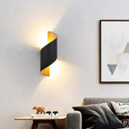 Modern living room with a black wall lamp, sofa, and decorative items.
