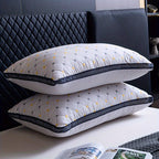Two white pillows with black and yellow patterns stacked on a bed.