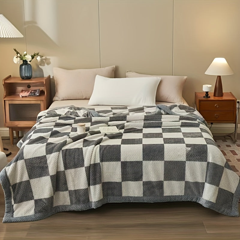 Bedroom with a checkered blanket on a bed, nightstands, and lamps.