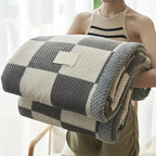 Person holding a checkered blanket with a white background
