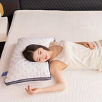 Woman lying on a bed with a pillow, wearing a white tank top.