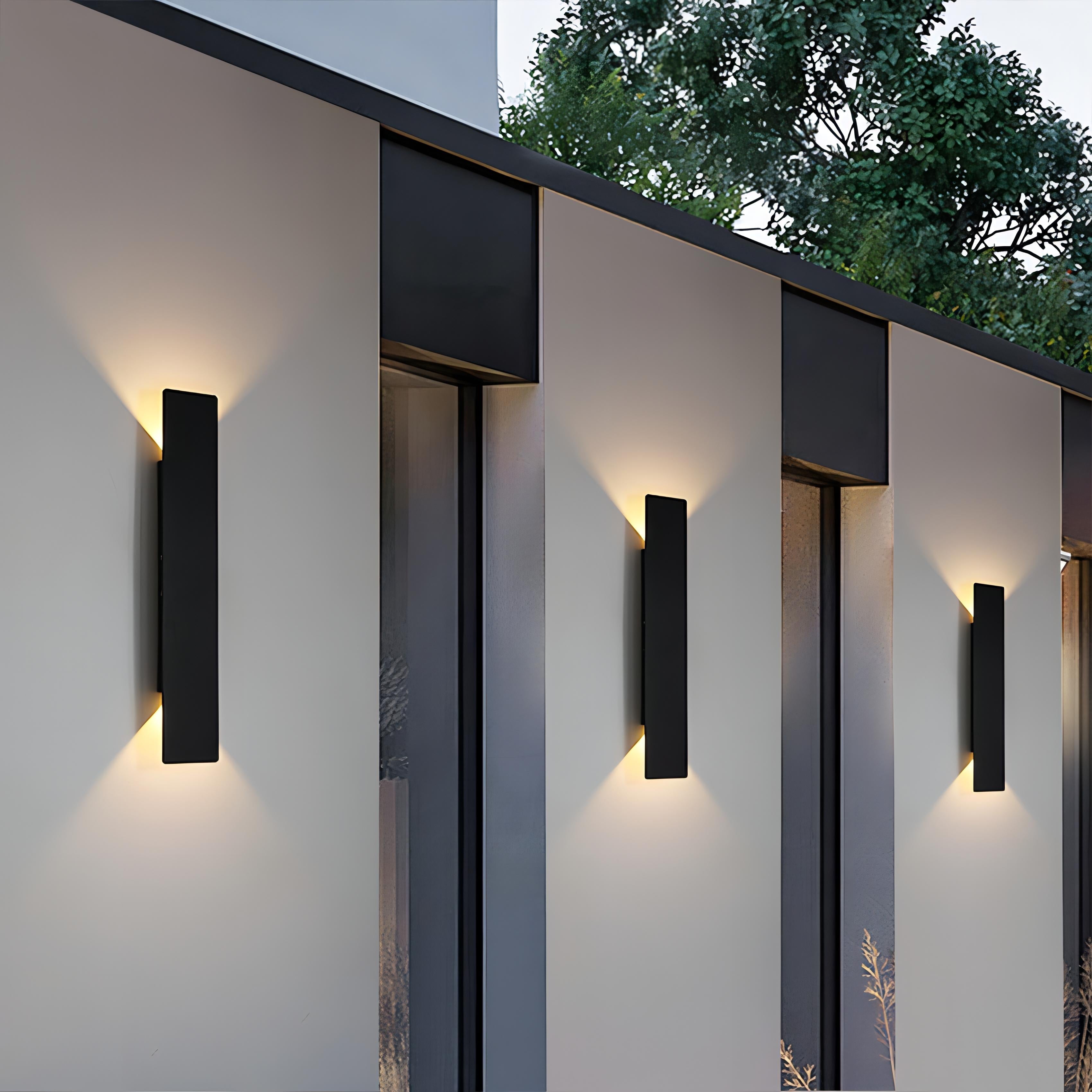 Modern outdoor wall lights on a building facade with trees in the background