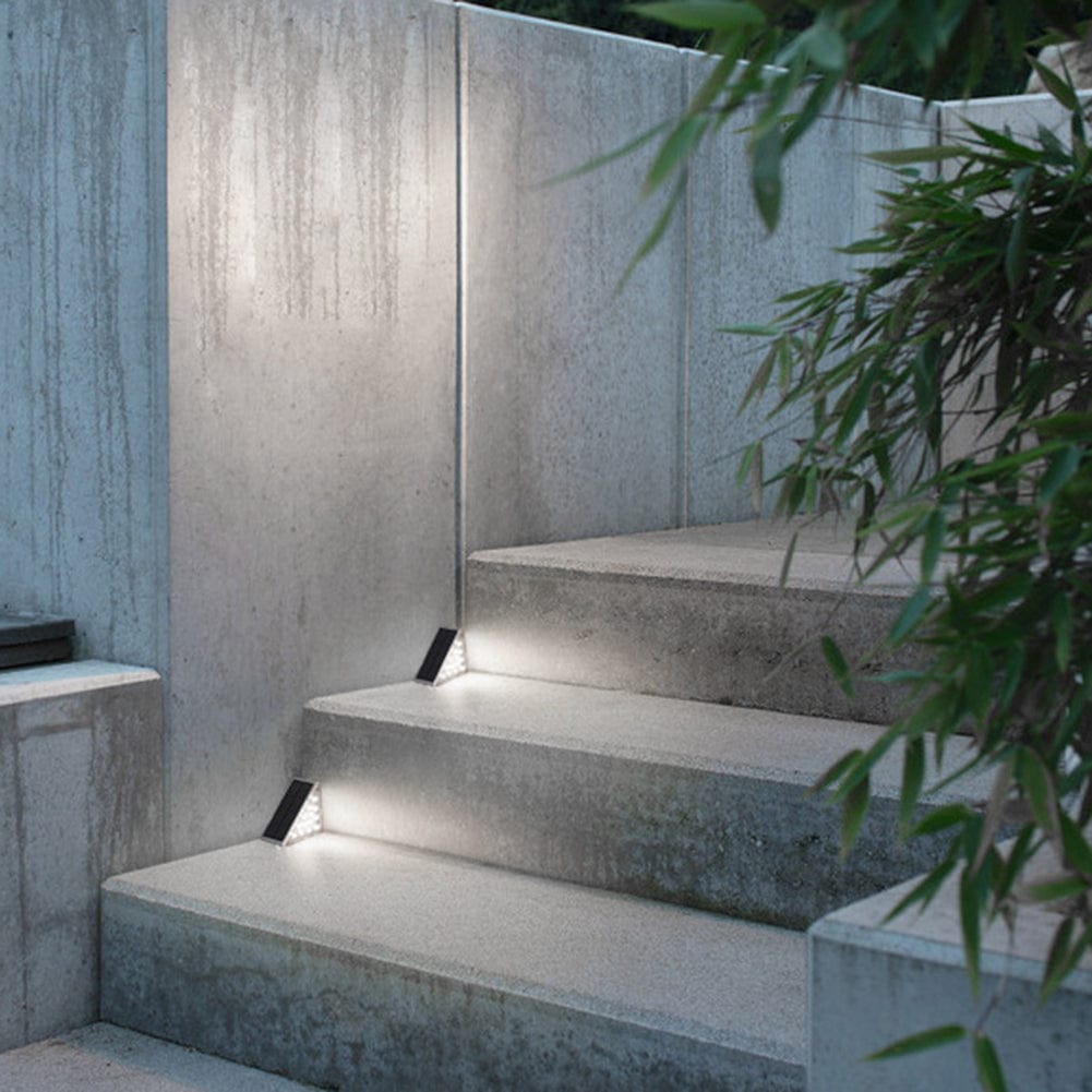 Concrete steps with embedded lights and a plant in the foreground