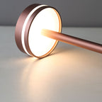Modern table lamp with a copper finish on a neutral background