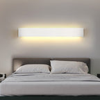 Modern bedroom with a bed and wall-mounted light fixture.