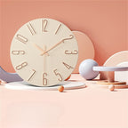 Wooden clock with rose gold hands on a pastel pink background