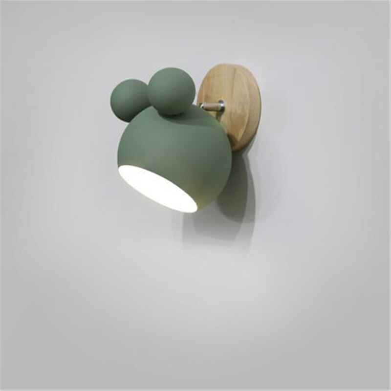 Green wall lamp with wooden base on a gray background