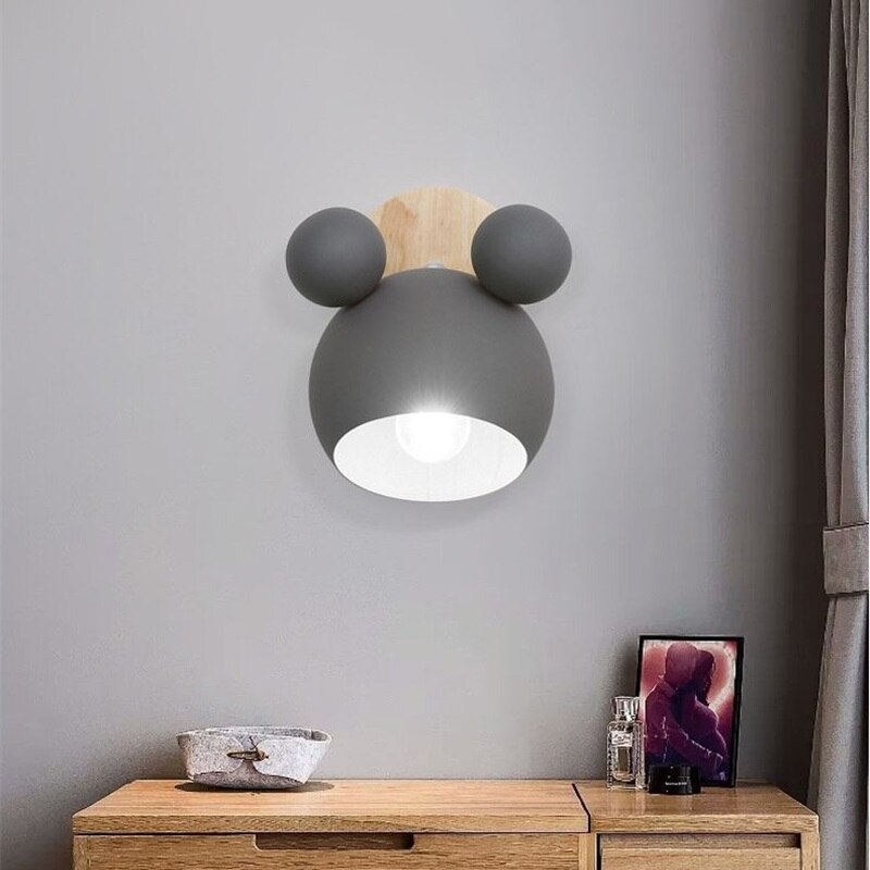 Modern wall lamp with round design on a gray wall above a wooden cabinet.
